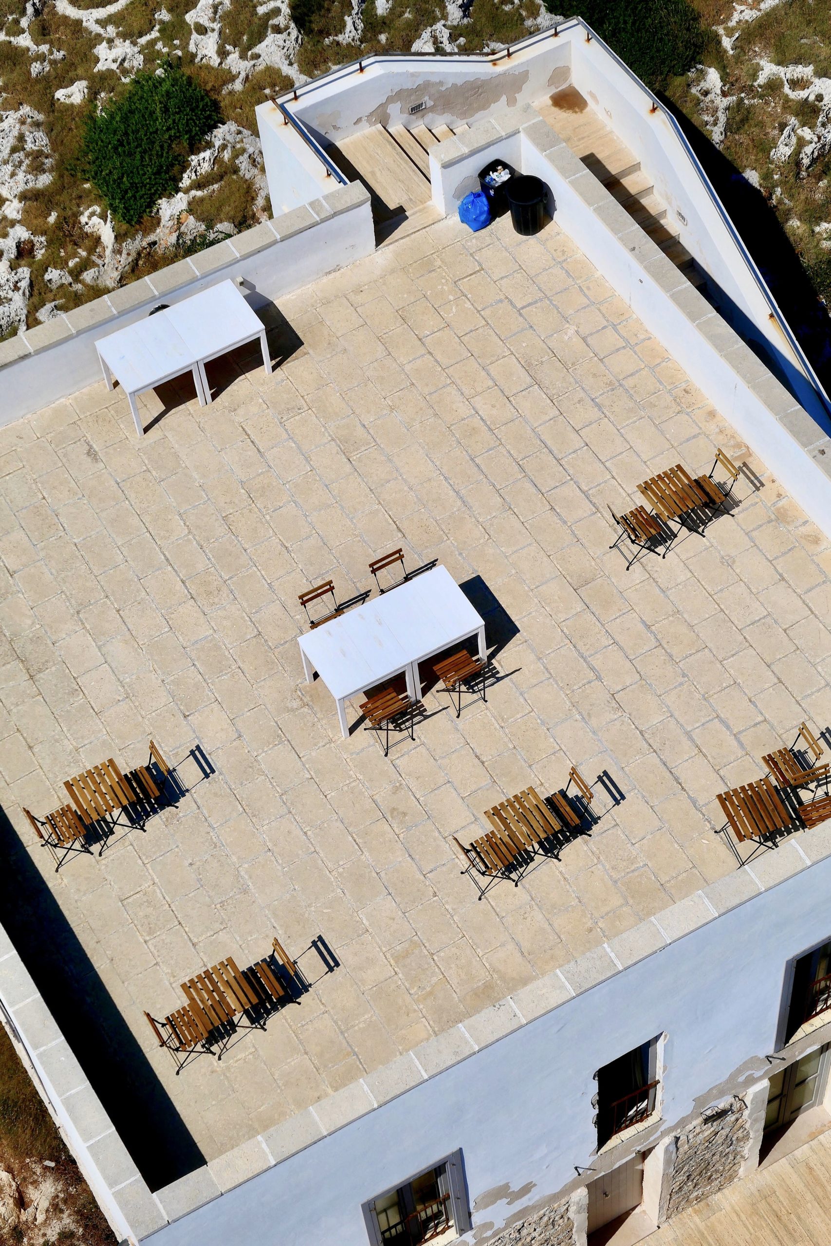 vertical-high-angle-shot-cafe-rooftop-light-blue-building-min