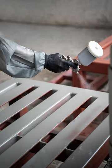 worker-spraying-powder-paint-from-gun-side-view_23-2149878752